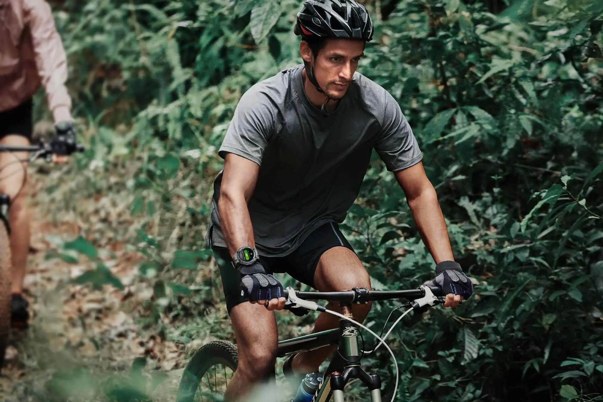 Mężczyzna jadący na rowerze z zegarkiem sportowym na ręce