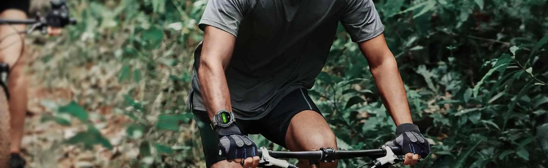 mężczyzna jadący na rowerze z zegarkiem sportowym na ręce