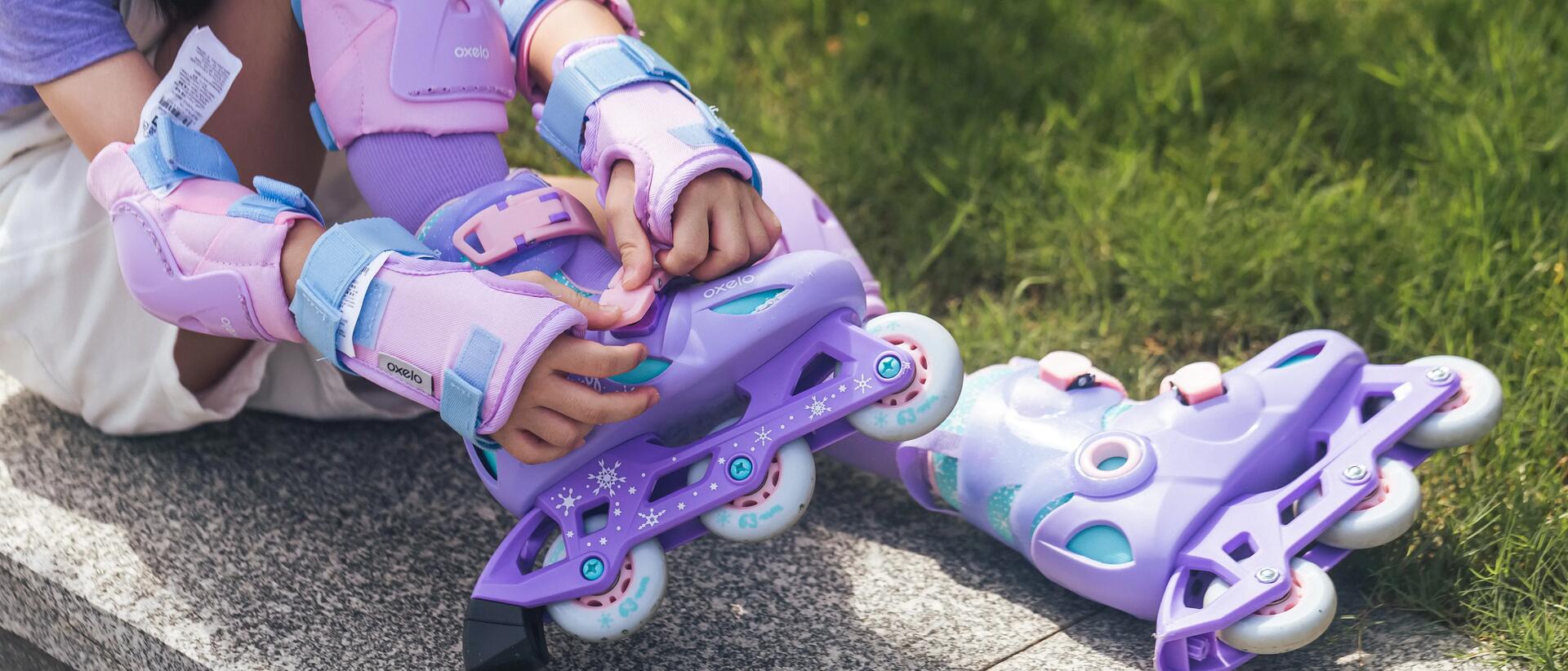 Child putting on roller skates on the ground