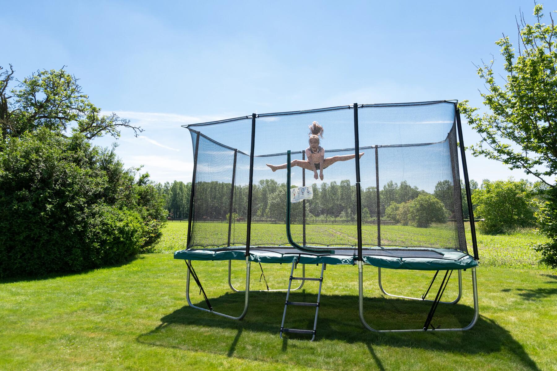 Een kind dat trampoline springt in een tuin
