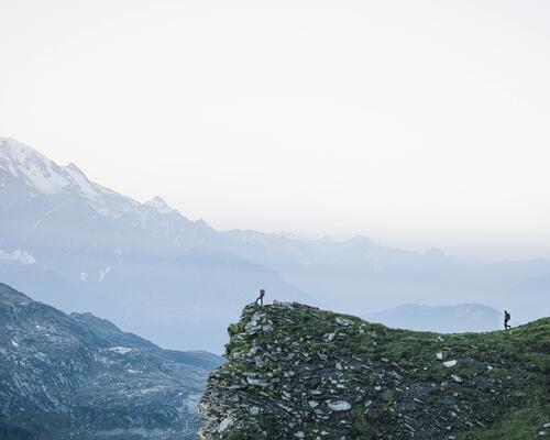 Photo de deux randonneurs au pied de montagnes