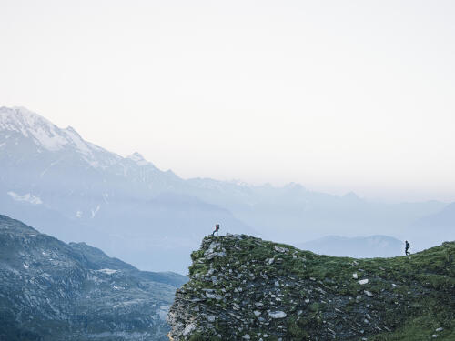 Photo de deux randonneurs au pied de montagnes