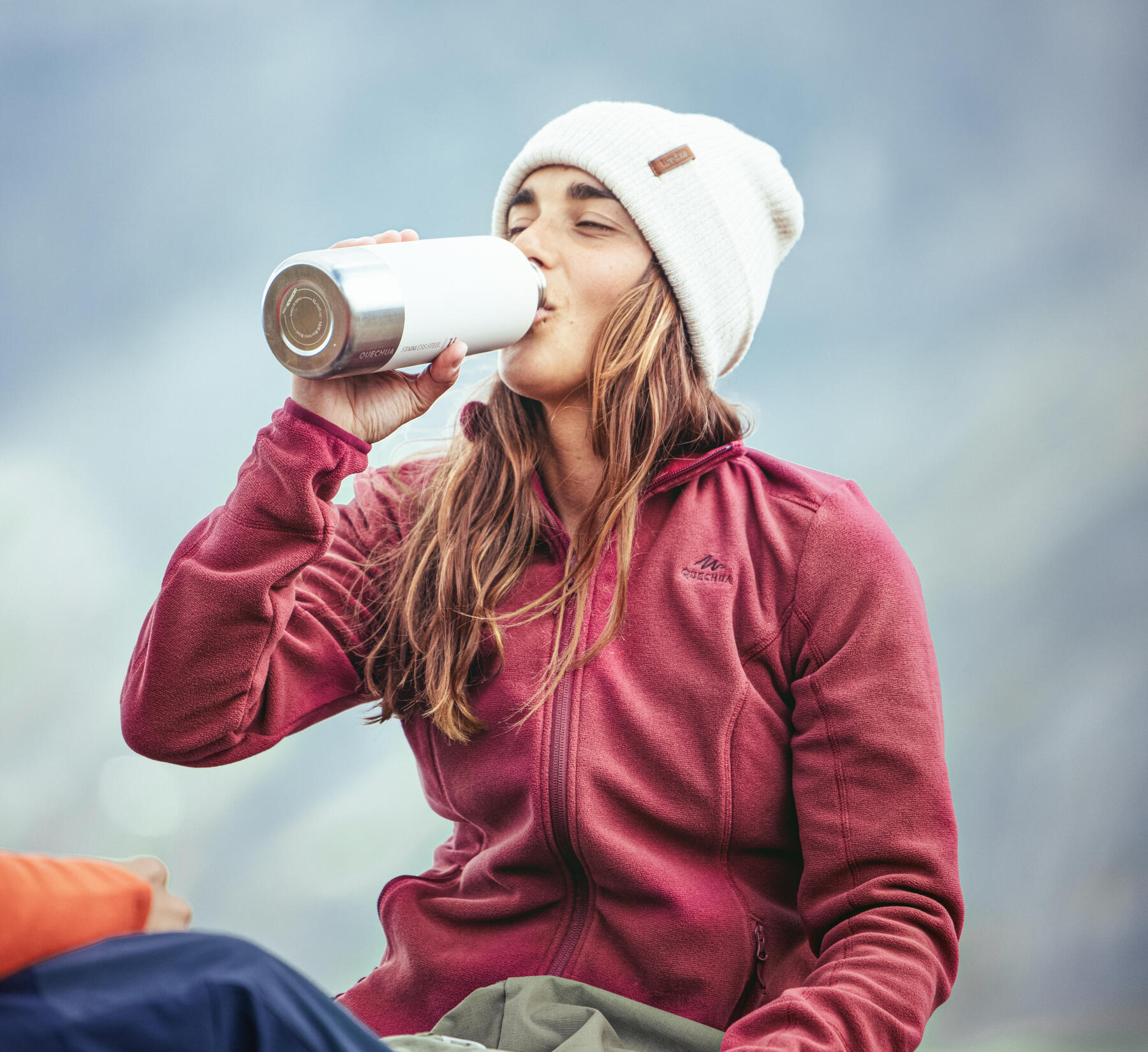 uma mulher a beber de um cantil decathlon