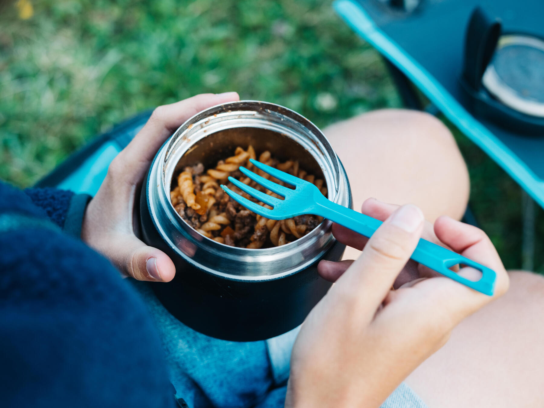 Boîte alimentaire isotherme en inox vue du dessus pendant une pause en camping