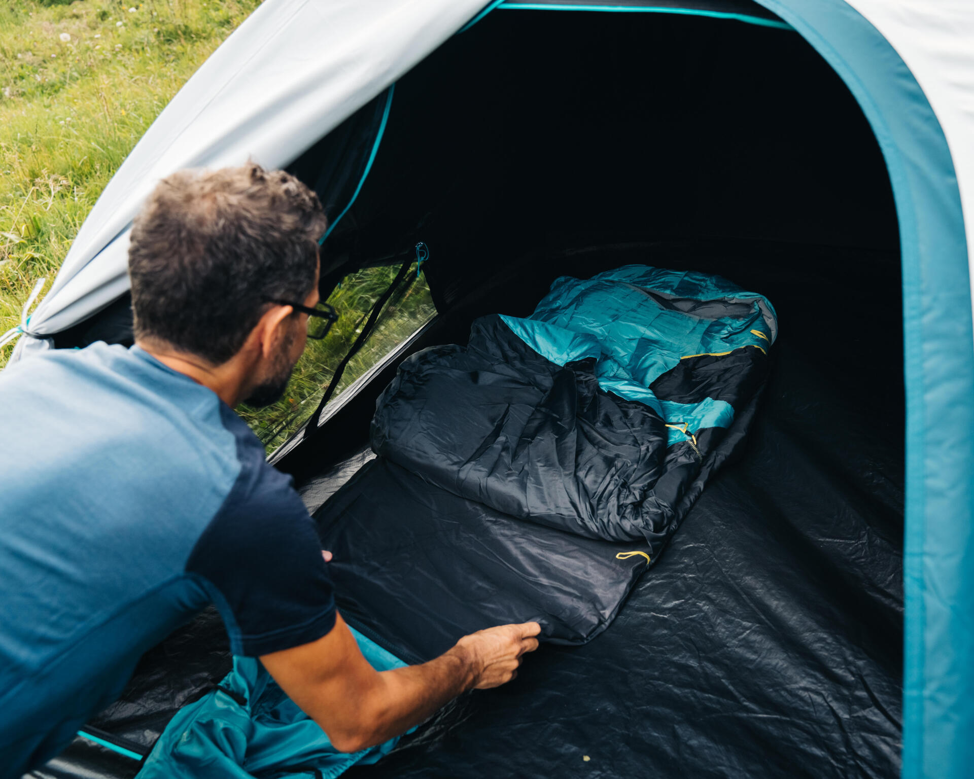 Un campeur installe un sac de couchage en prévision de la nuit pour observer les étoiles