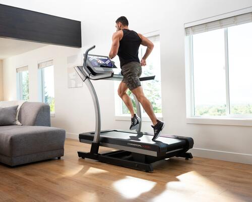 Ein Mann steht in Kleidung für Cardiotraining auf dem Laufband