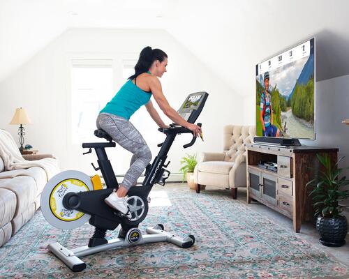 kobieta w stroju sportowym na rowerze stacjonarnym