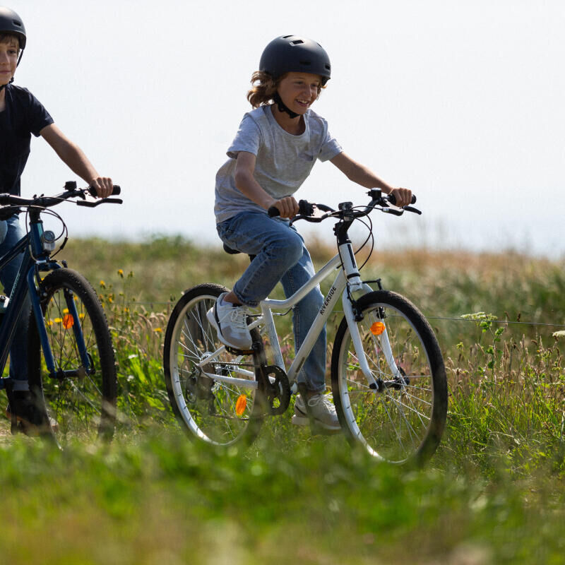 Duas crianças a andar de bicicleta na natureza