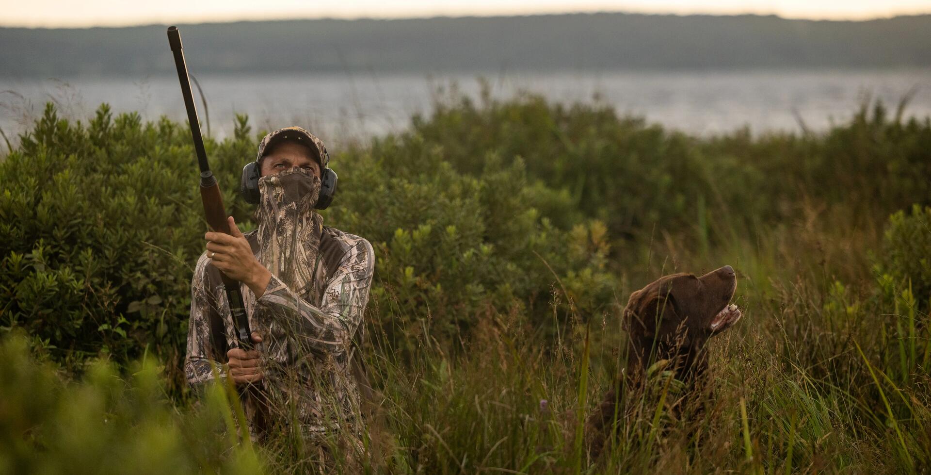 cazador y perro de caza esperando camuflados