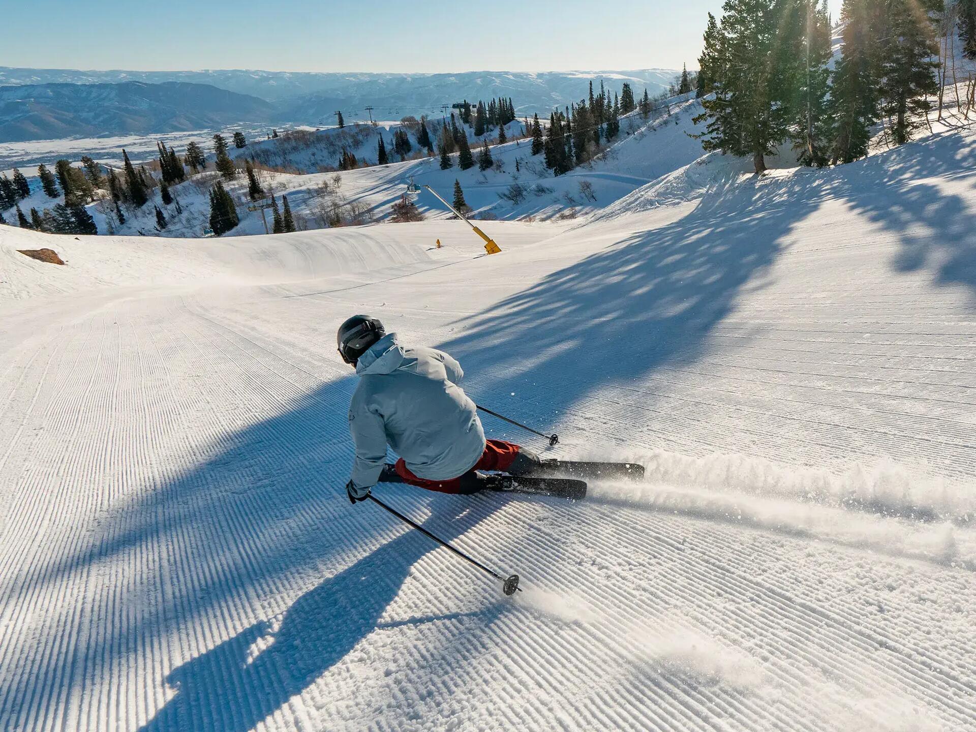 osoba w odzieży narciarskiej wykonująca śmig zjeżdżając ze stoku narciarskiego
