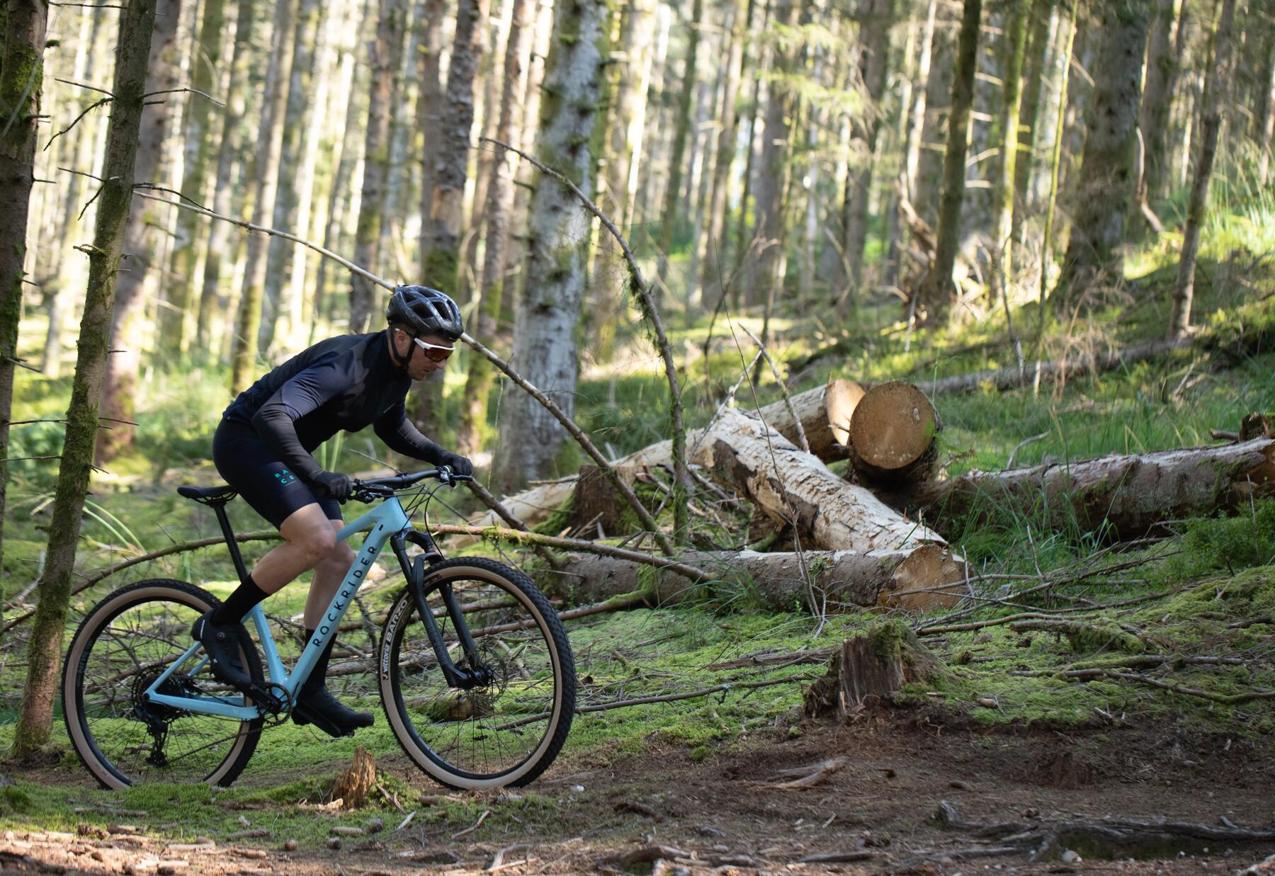 mężczyzna w kasku i odzieży rowerowej jadący na rowerze MTB 