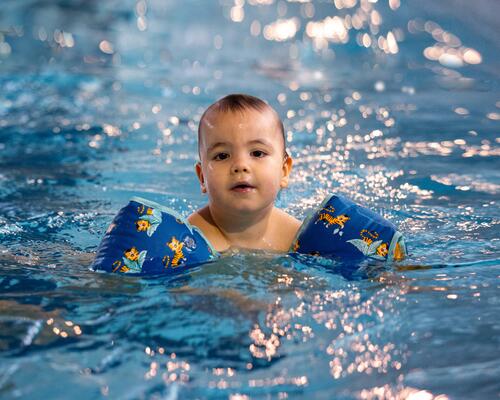 crianca com braçadeiras de piscina