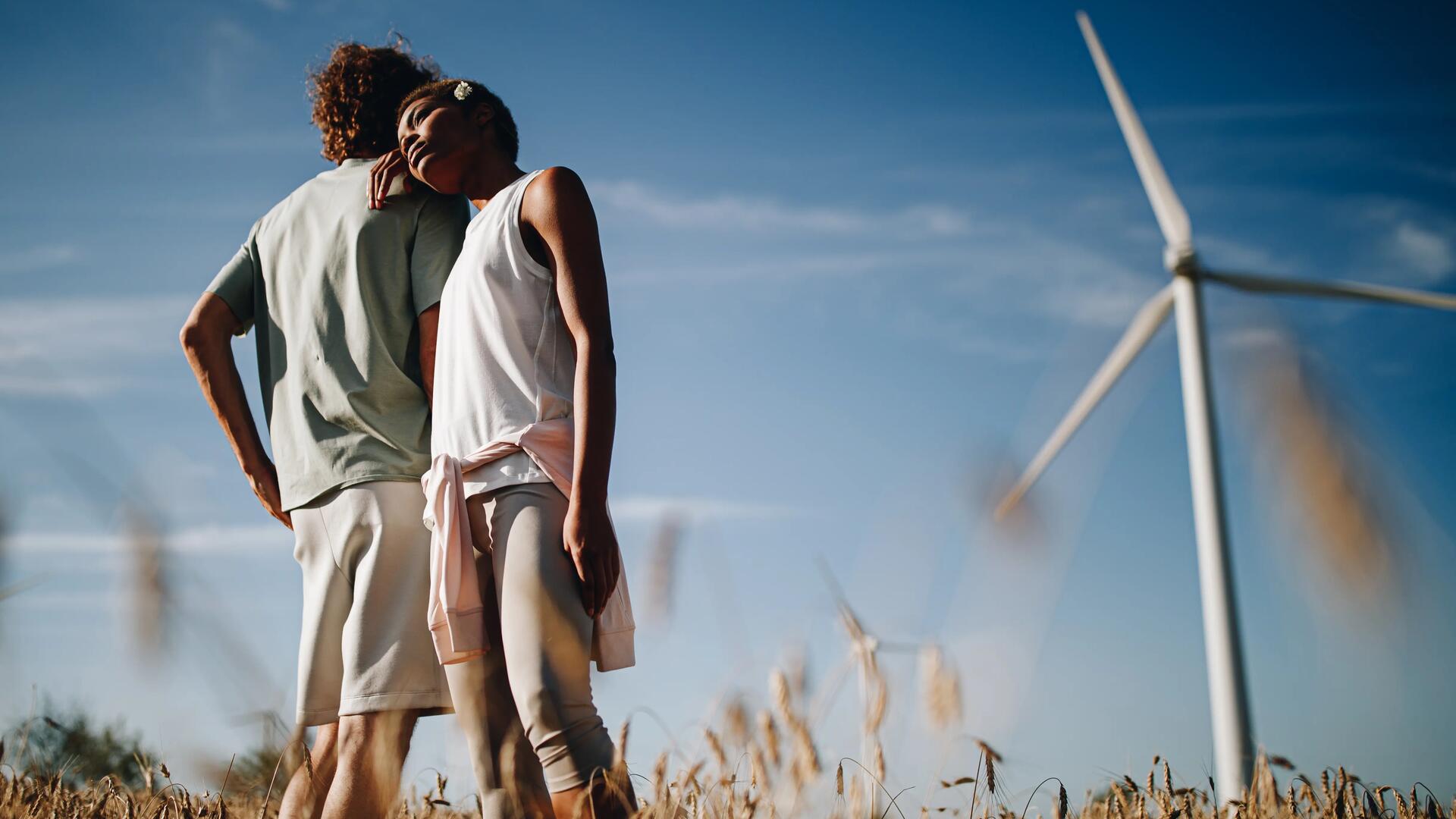 Photo couple devant une éolienne
