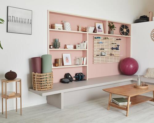 Ett minimalistiskt inrett rum där träningsutrustning är en diskret del av dekoren