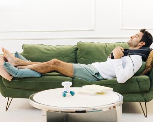 homem a relaxar no sofá com acessório de massagem decathlon