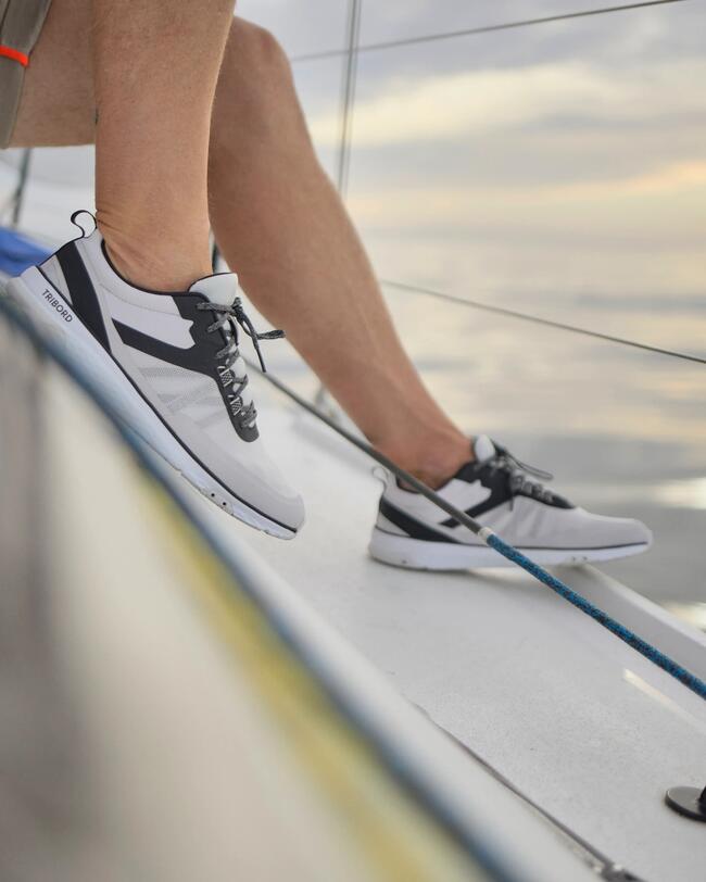 photo d'un homme portant une paire de basket bateau race noires sur un bateau