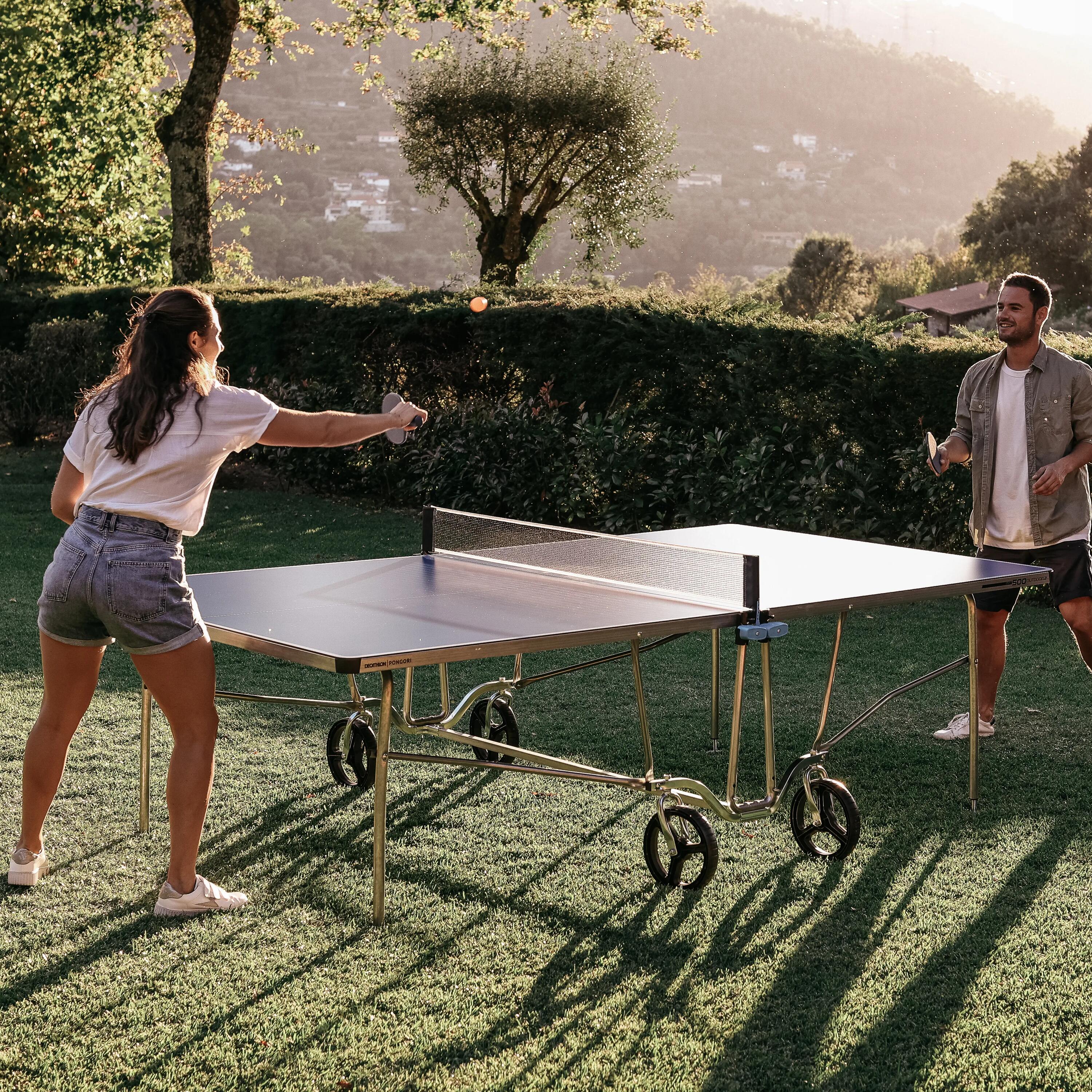 Ein Mann und eine Frau spielen Tischtennis im Garten