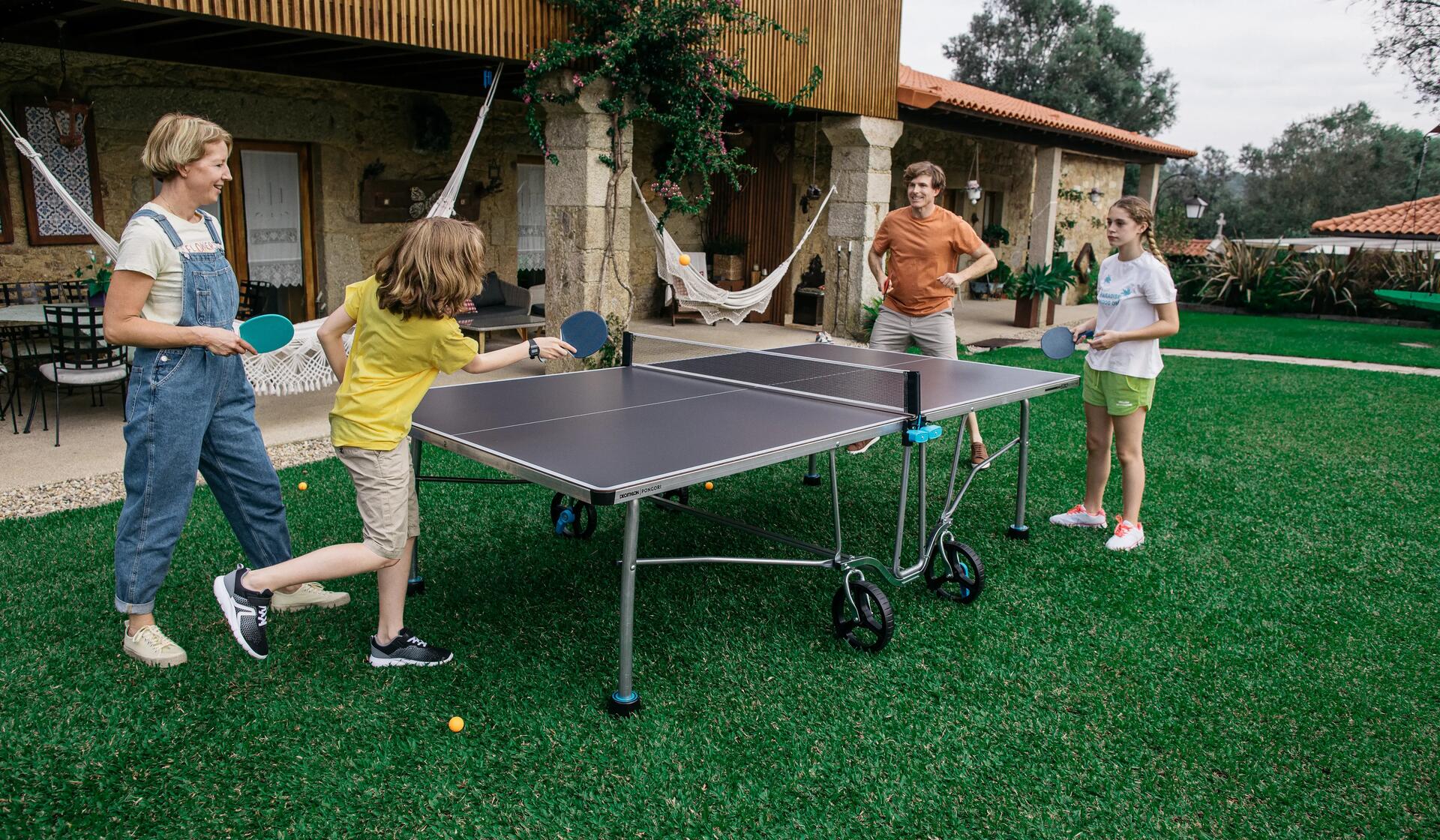 Eine Familie spielt Tischtennis mit unserer Outdoor-Tischtennisplatte PPT 530.2 OUTDOOR BLAU