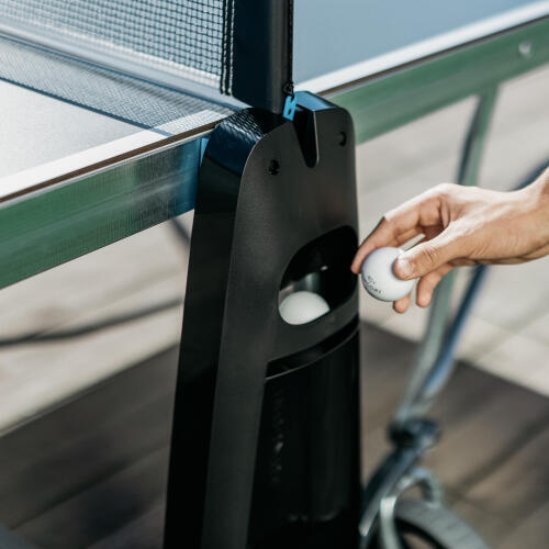 PPT 900 OUTDOOR .2 dış mekan masa tenisi masasının üzerinde bulunan top ve raket tutuculara konan topun yakından görünümü