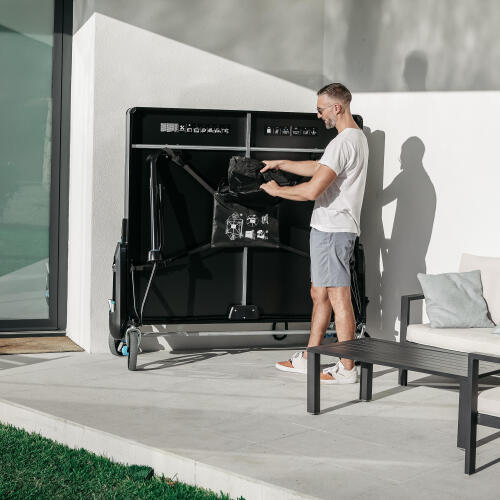 Bir kişi, PPT930 OUTDOOR .2 masa tenisi masasıyla birlikte gelen kılıf çantasını açıyor