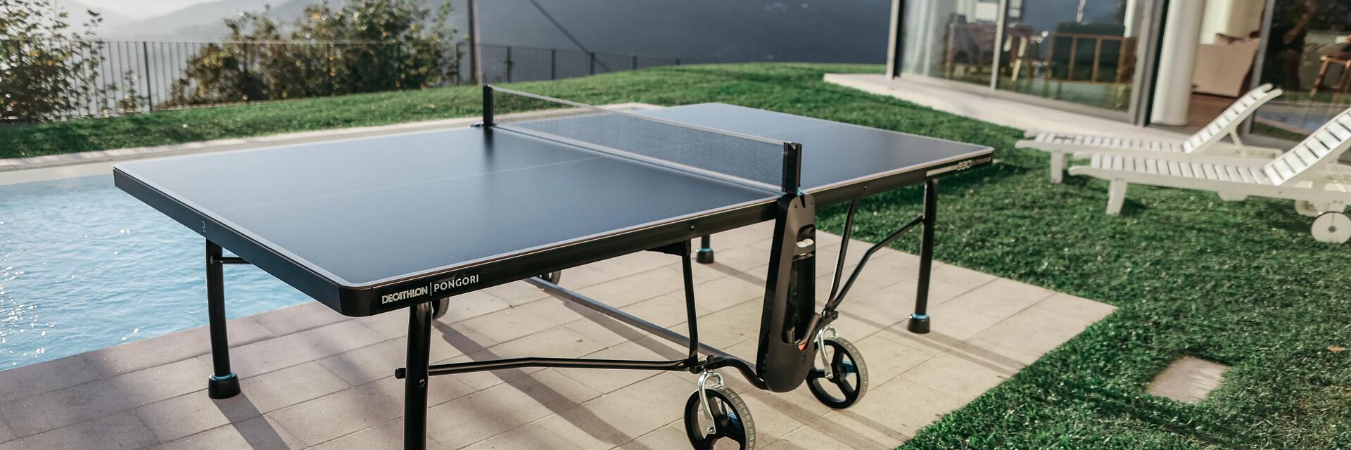 Eine Tischtennisplatte steht im Garten neben dem Pool