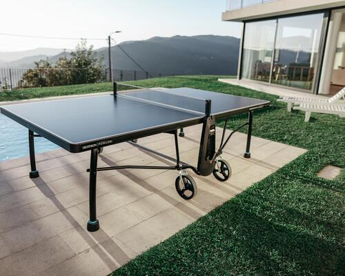 Eine Tischtennisplatte steht im Garten neben dem Pool