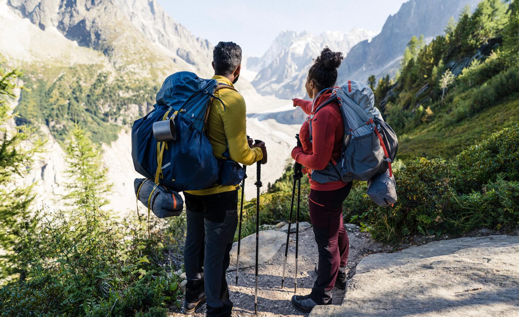 kobieta i mężczyzna stojący na szlaku górskim z plecakami turystycznymi na plecach