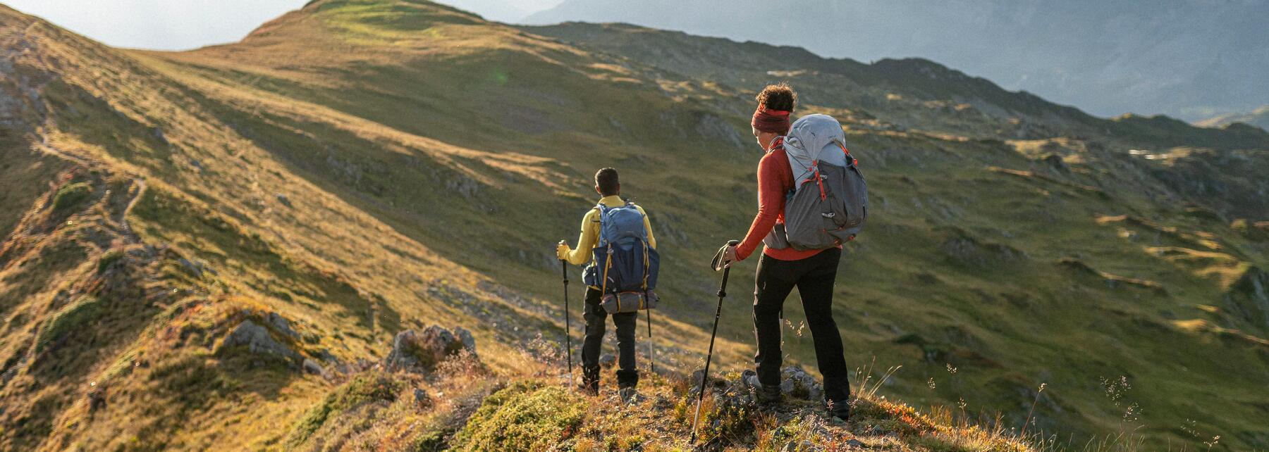 Two people backpacking in a mountain using hiking poles