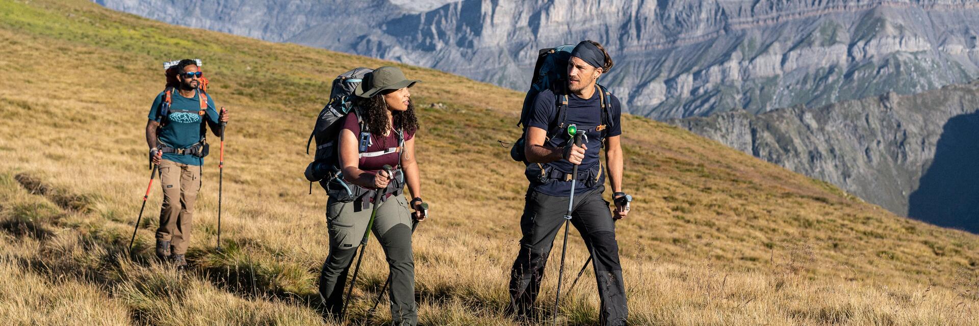Eine Gruppe aus 3 Leuten schaut nach den Beschilderungen von Wanderwegen