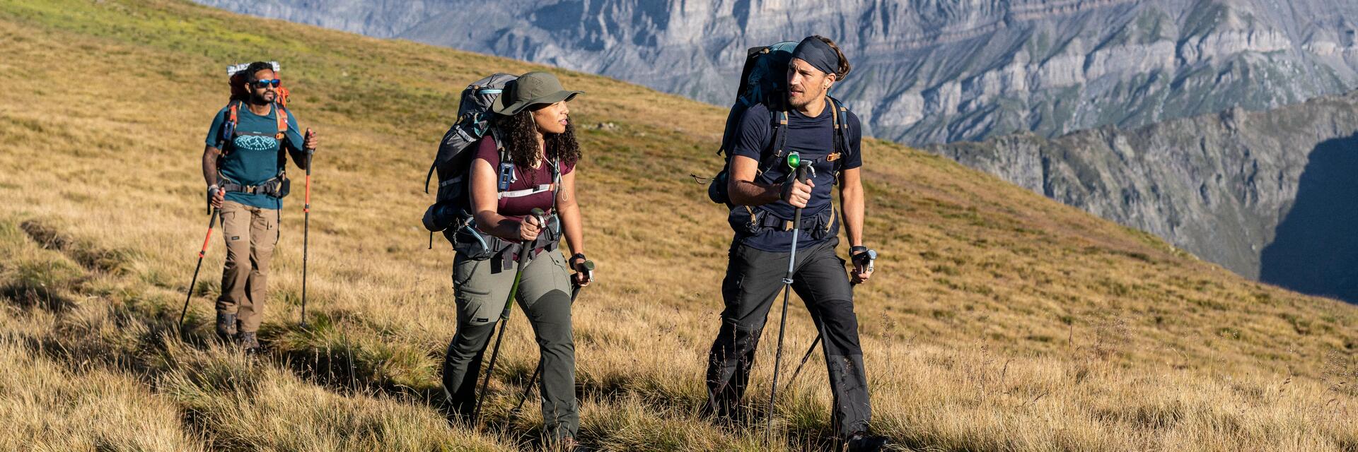Mężczyźni idący w góry z kijkami trekkingowymi