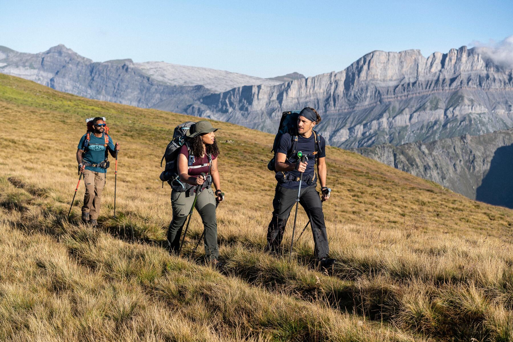 Ludzie wędrujący po górach z kijkami trekkingowymi w rękach