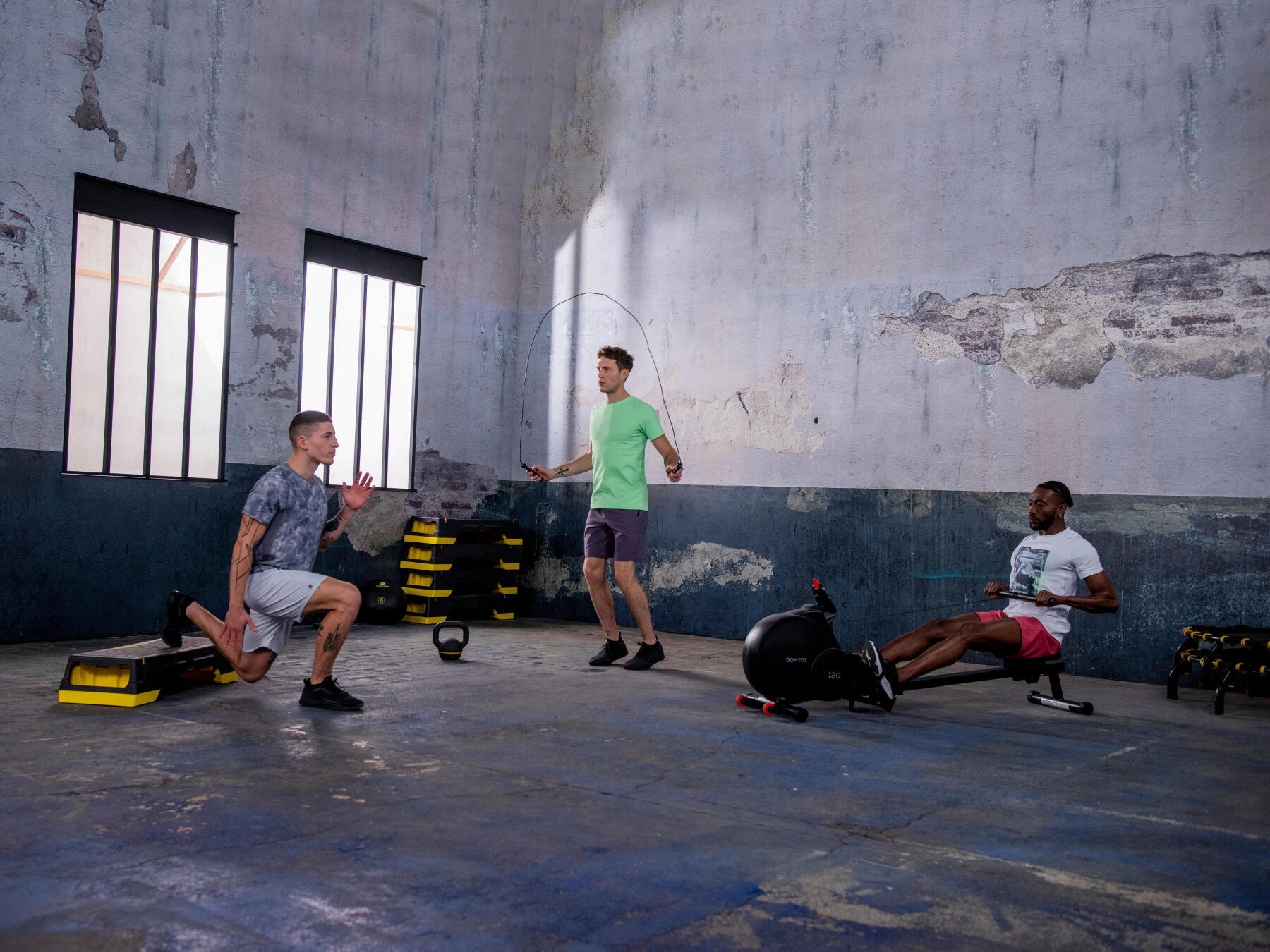 três homens a praticarem exercício físico com diverso material