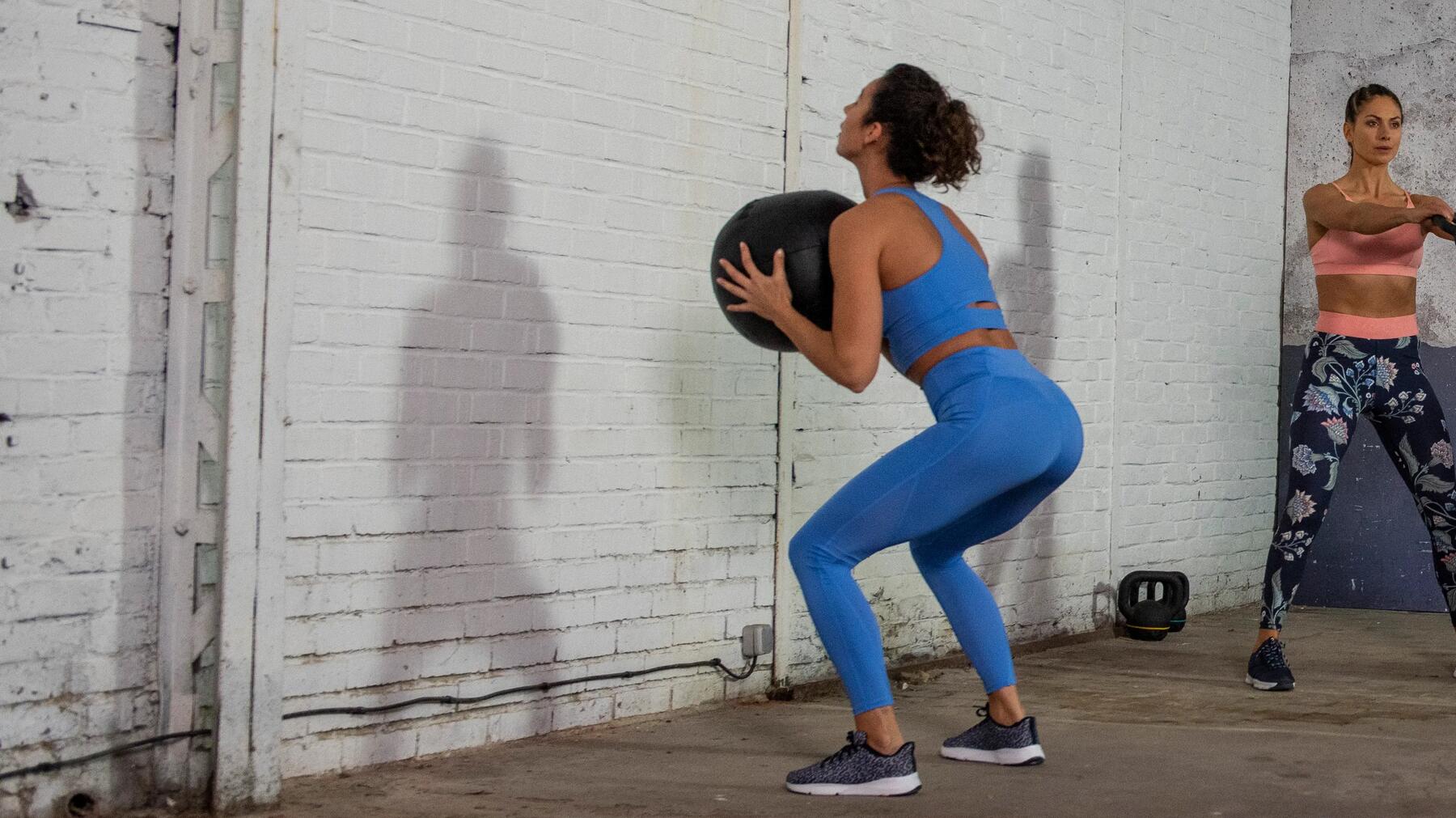 mujer haciendo wall ball con balón medicinal