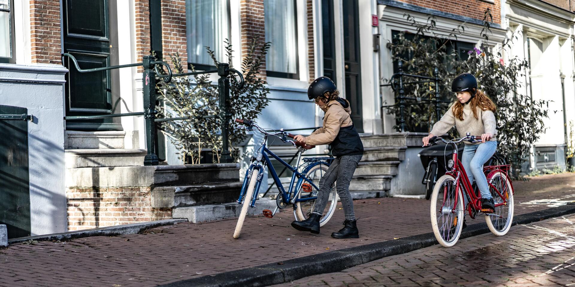 dziewczynka i chłopiec z kaskami rowerowymi na głowach  na rowerach miejskich