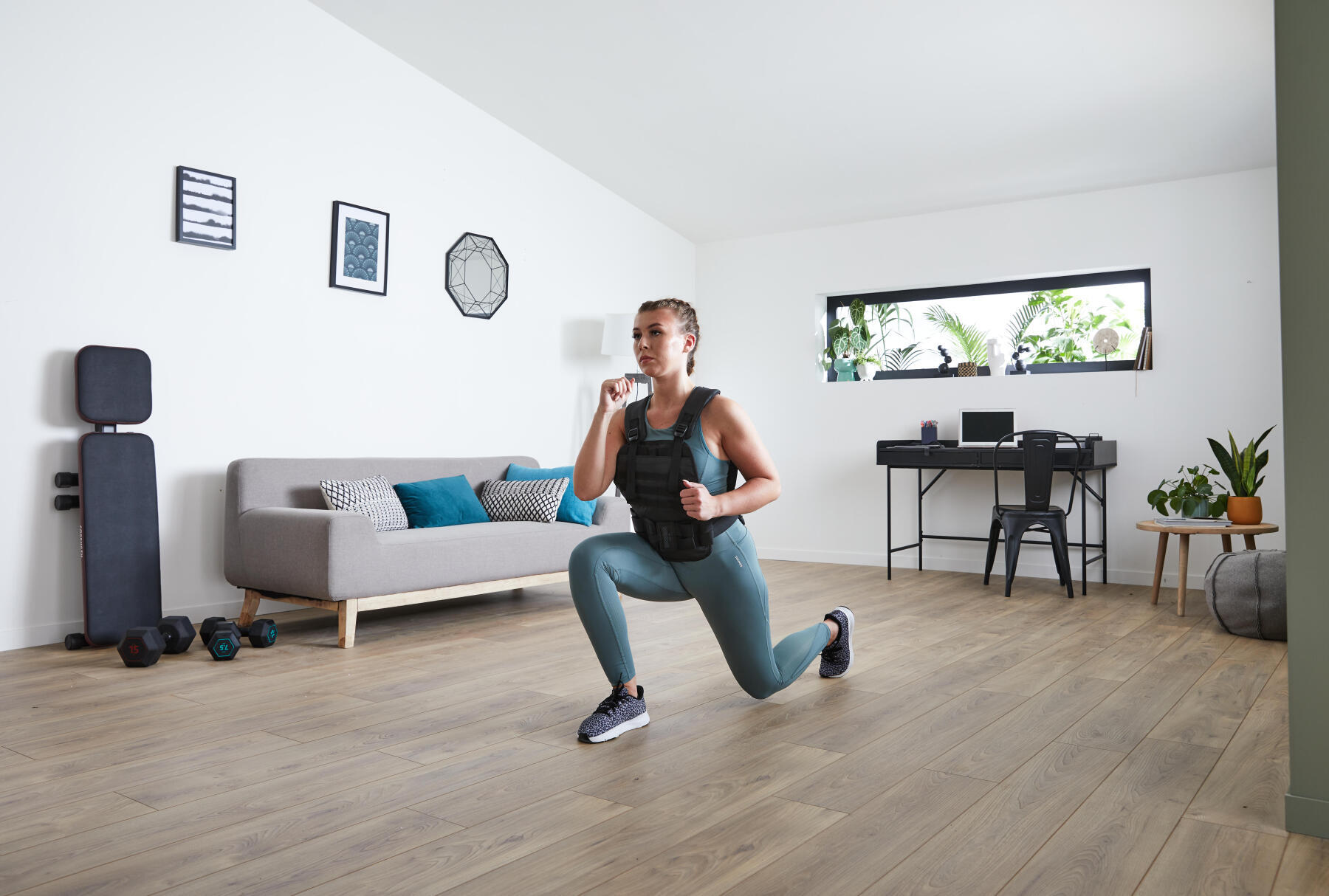 mulher a fazer o exercíco de afundo frontal com colete de peso corength