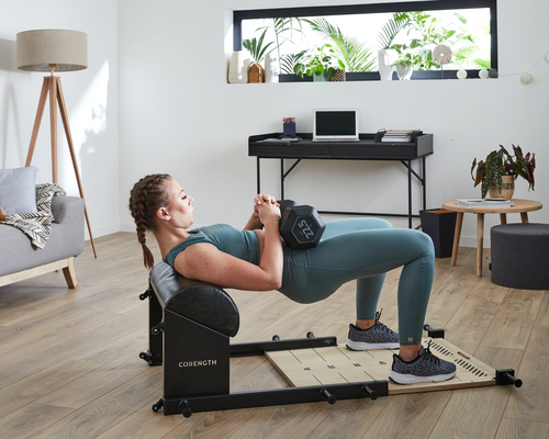 Kobieta w odzieży sportowej ćwicząca hip thrust z hantlem 