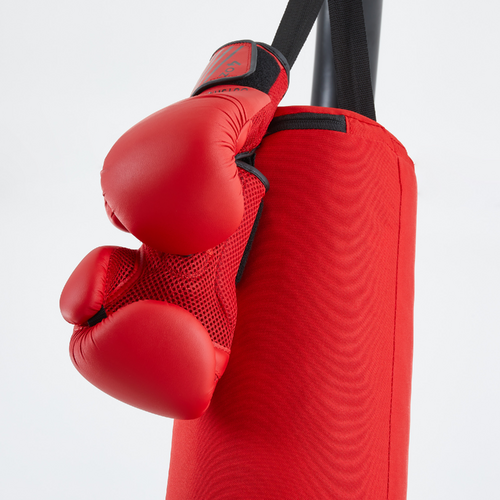 Poing D'un Homme Avec Un Gant De Boxe Rouge Frappant Un Sac De Boxe Noir  Sur Un Mur Noir