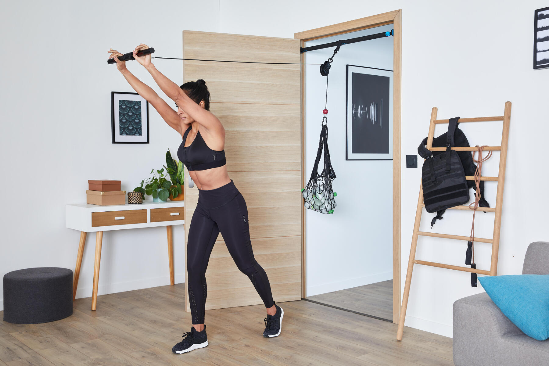 Kobieta w stroju fitness prostująca ramiona na wyciągniku