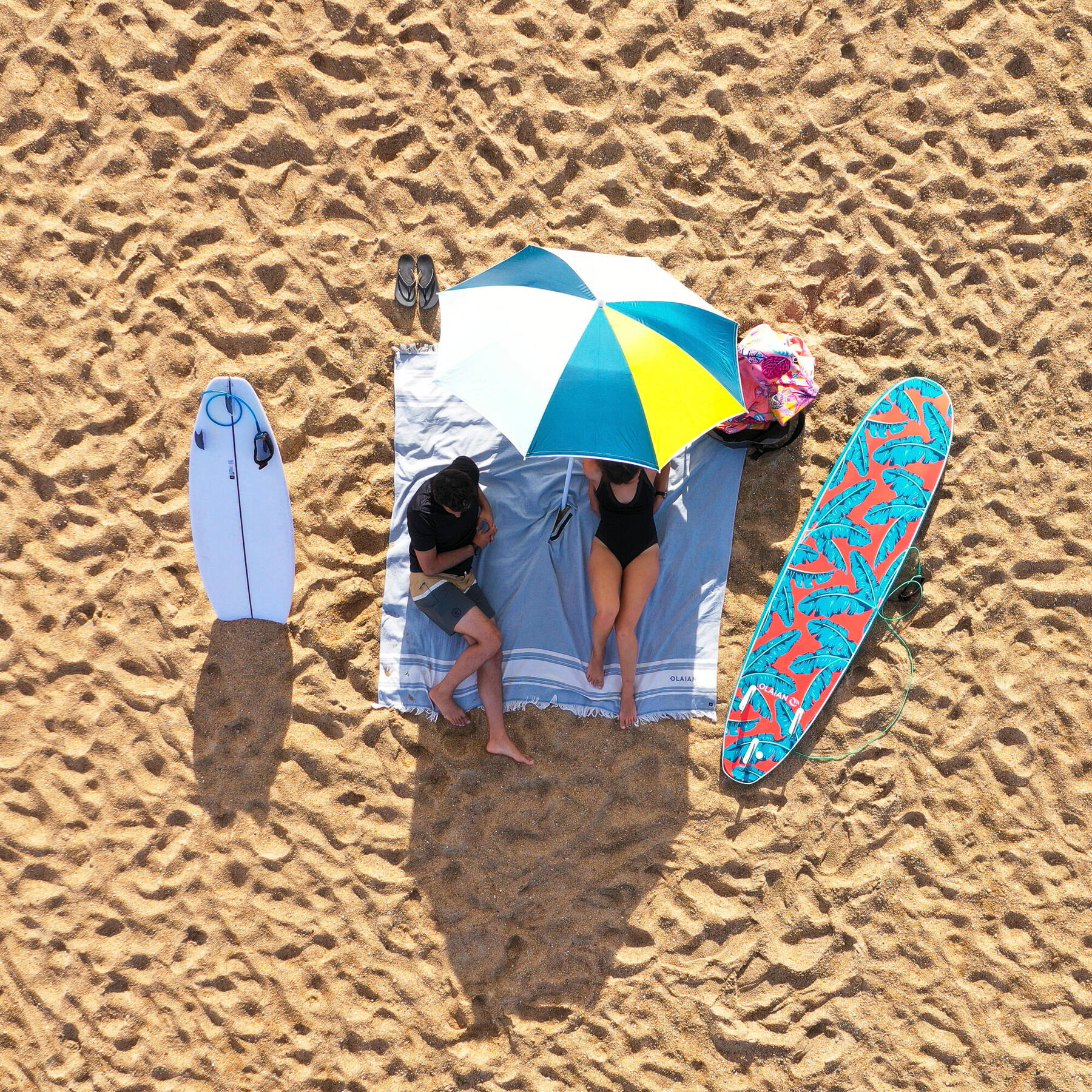 Kobieta i mężczyzna leżący na dużym ręczniku plażowym