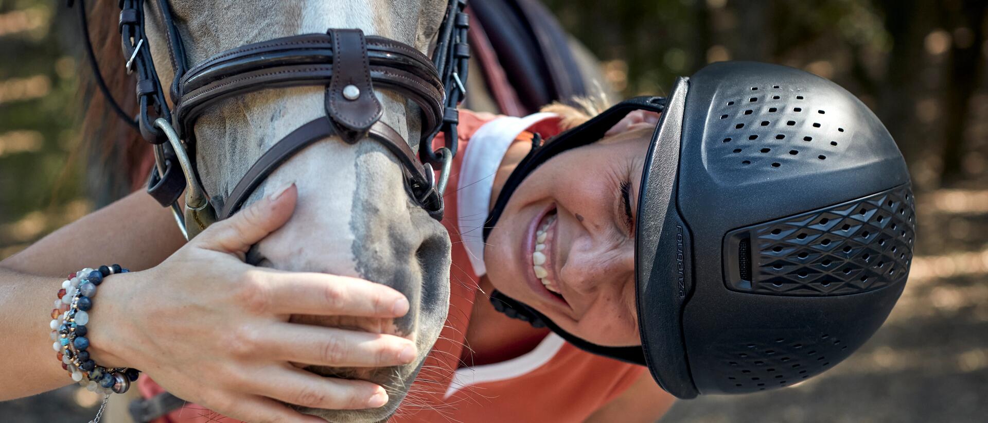 A woman in a well ventilated Horse Riding Helmet with a Horse