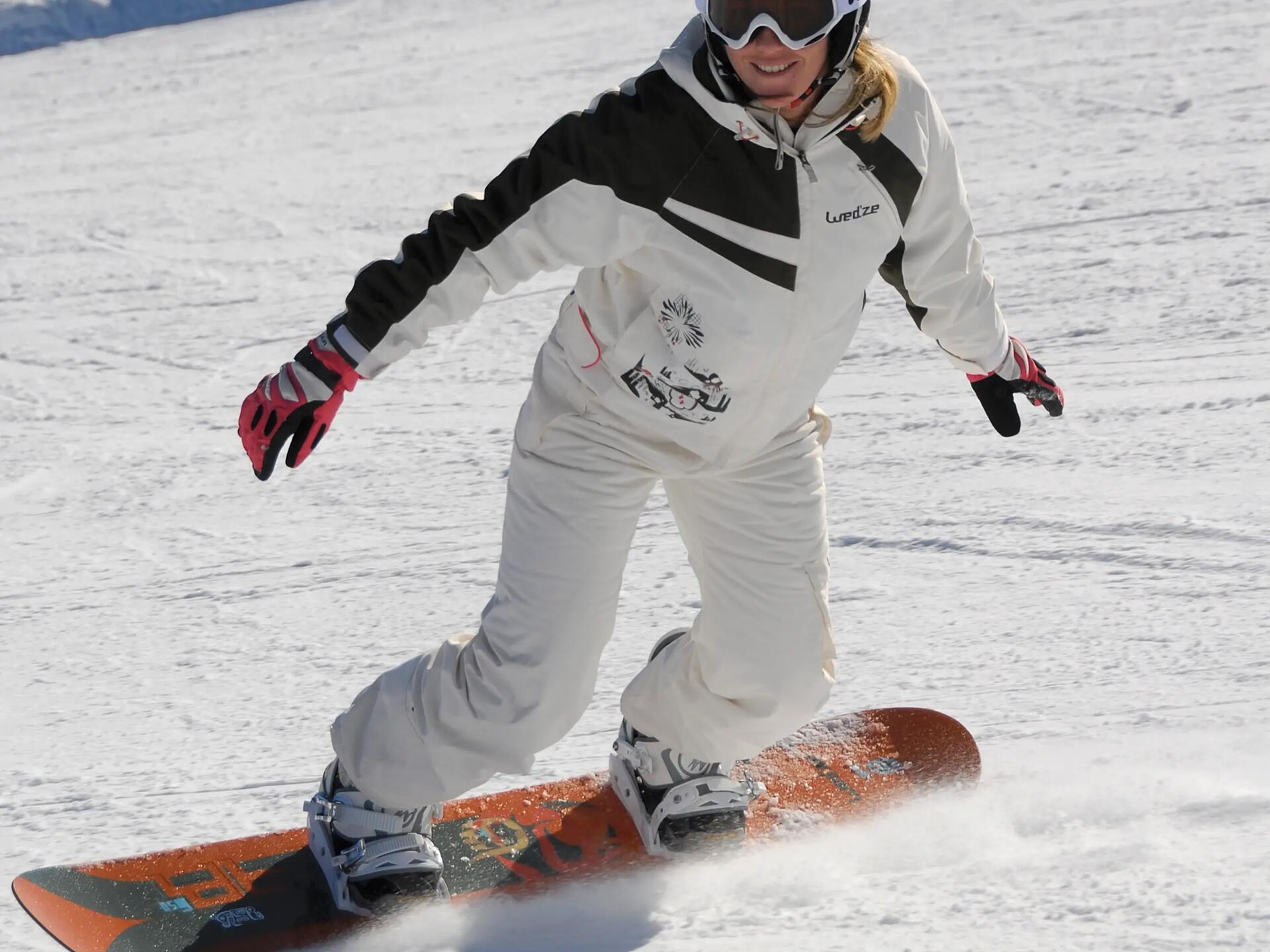 kobieta jadąca na snowboardzie w butach snowboardowych