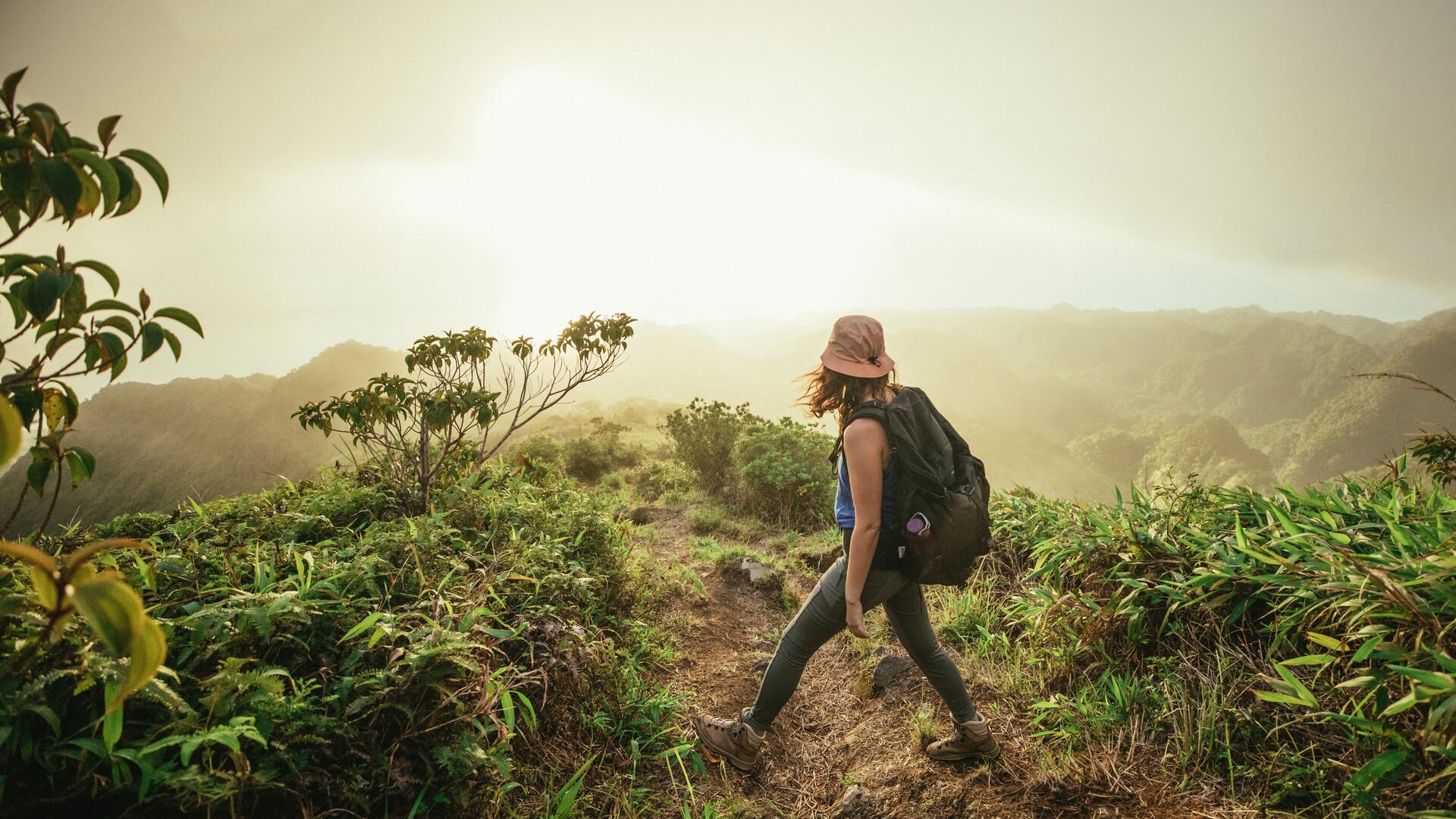 kobieta z plecakiem turystycznym na plecach wędrująca w plenerze w butach trekkingowych