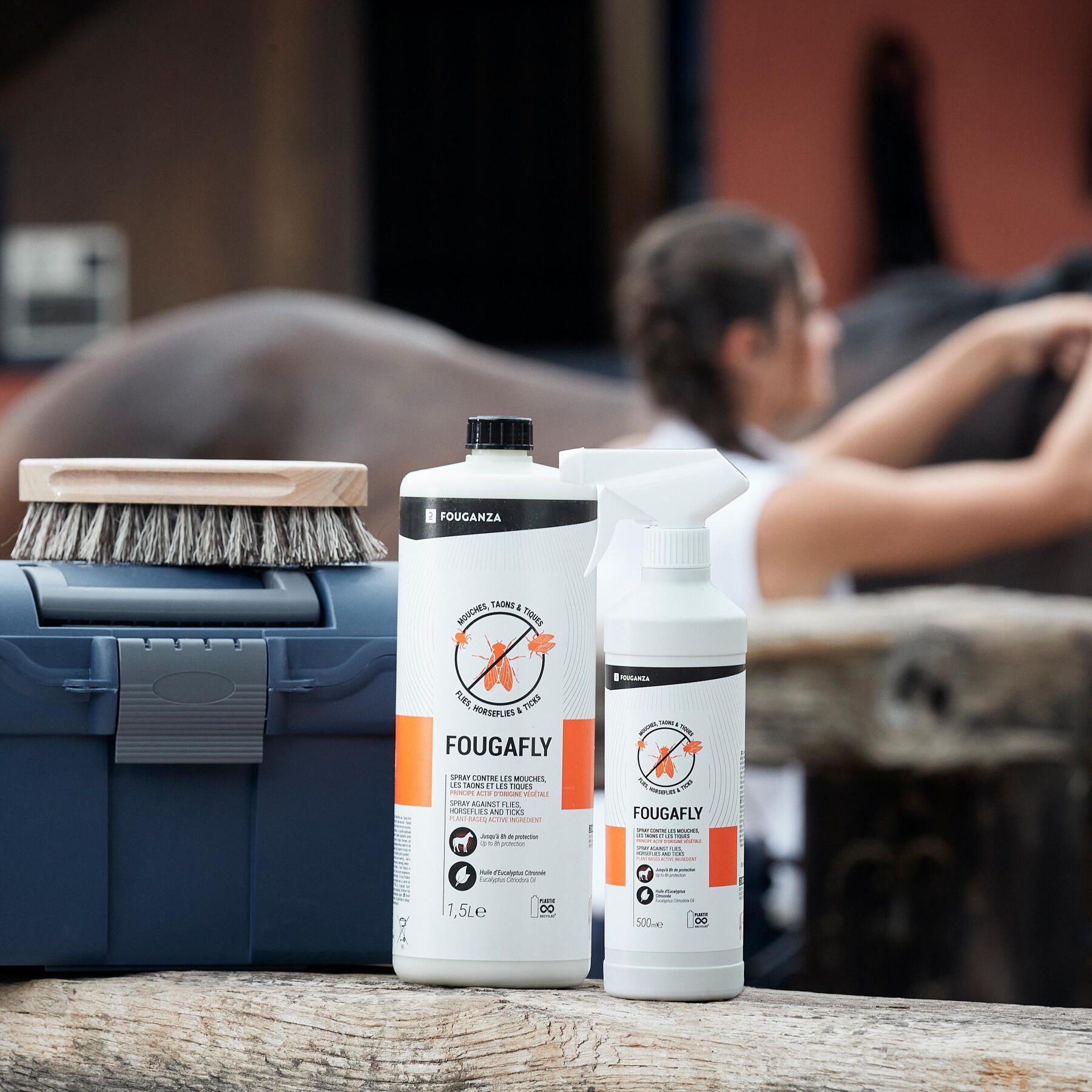 cavalière en train de pulvériser du produit insectifuge sur son cheval