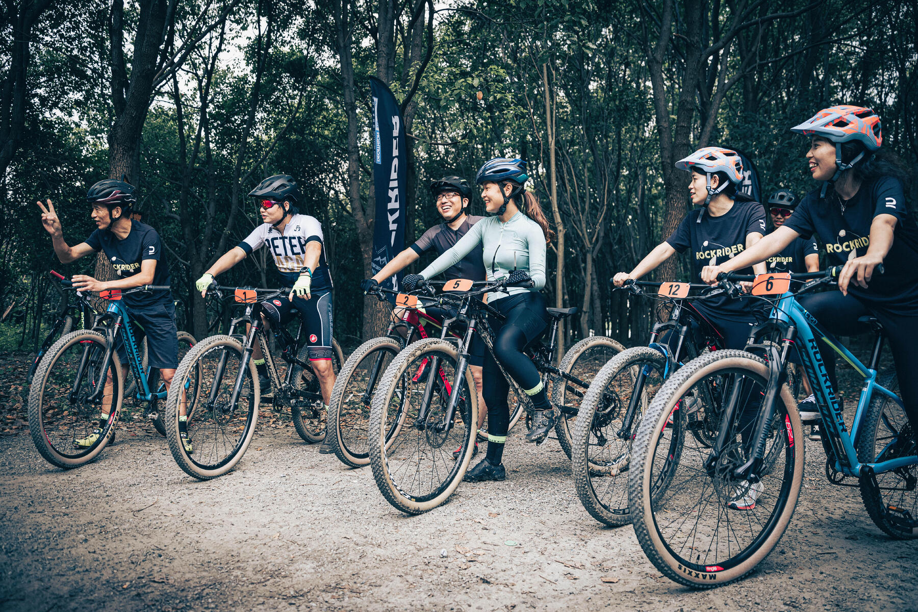 Rowerzyści w kaskach stojący na rowerach przed singletrack