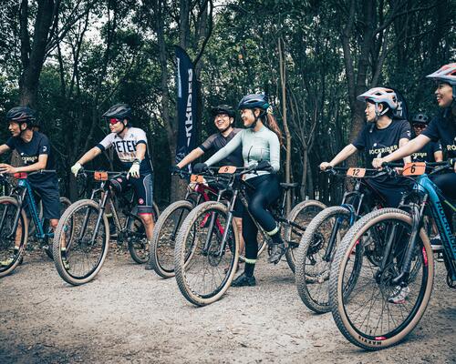 Rowerzyści w kaskach stojący na rowerach przed singletrack