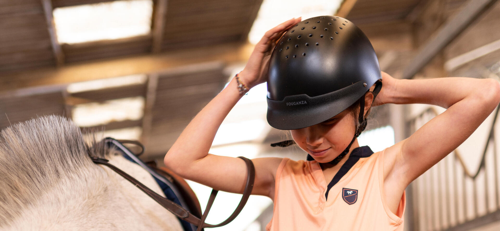 jeune cavalière en train de régler son casque d'équitation