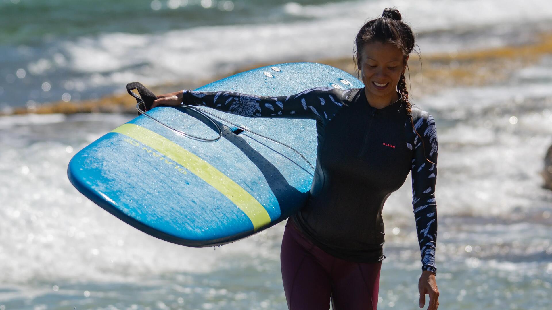 femme souriant après une session de surf 