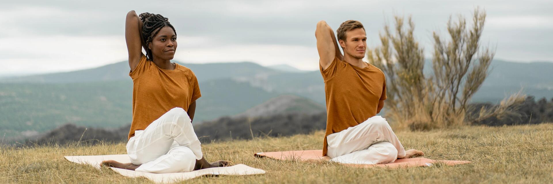 Para ćwicząca w plenerze na macie jogę pozycję gomukhasana