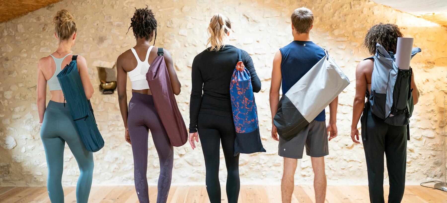 A group of people posing with a variety of Yoga bags and Slings. 