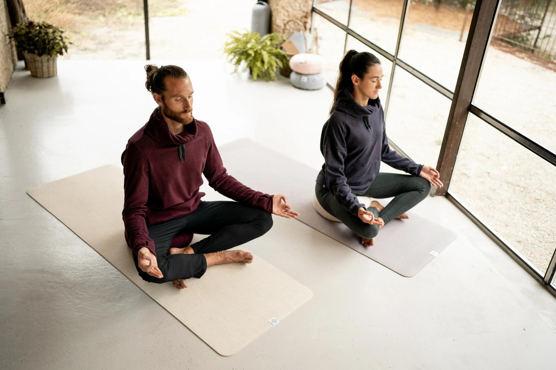Kobieta i mężczyzna medytujący na matach do jogi z aplikacją do relaksacji